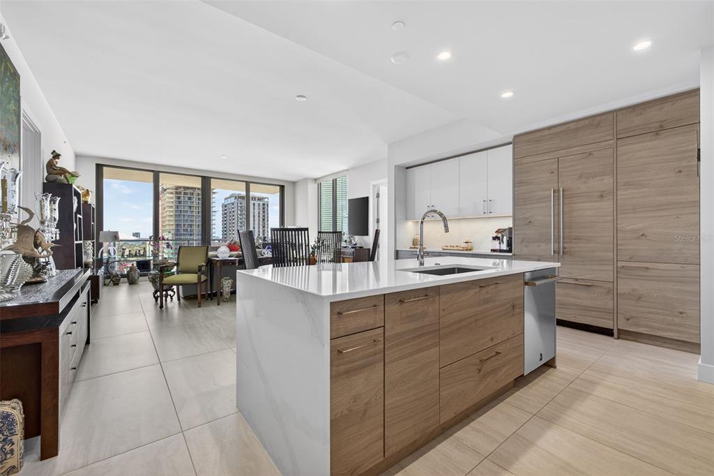 A modern kitchen with wood-toned cabinetry and a white waterfall island overlooks a city view — 301 1ST STREET S UNIT 1505, ST PETERSBURG, FL