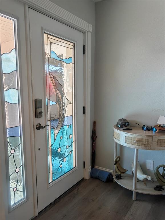 An entryway features a white door with a stained glass dolphin design and a console table — 542 BOCA CIEGA POINT BOULEVARD N UNIT 2108, MADEIRA BEACH, FL