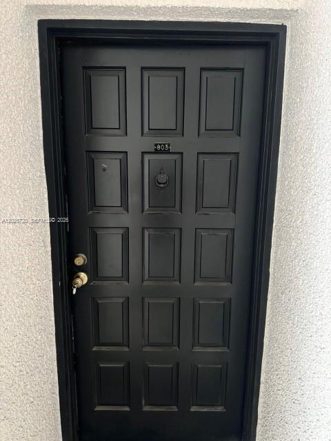 A black door with a door knocker and the number 803 is set in a wall — 3301 Spanish Moss Ter # 803, Lauderhill FL 33319, LAUDERHILL, FL
