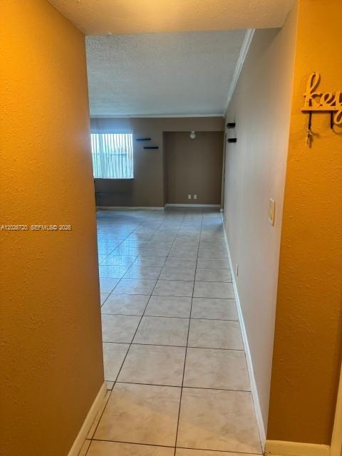 A view from a hallway looking into a tiled living area with a window — 3301 Spanish Moss Ter # 803, Lauderhill FL 33319, LAUDERHILL, FL