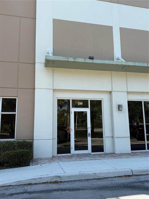 The exterior of a commercial building unit features a glass door labeled 109 — 1000 STINSON WAY, WEST PALM BEACH, FL