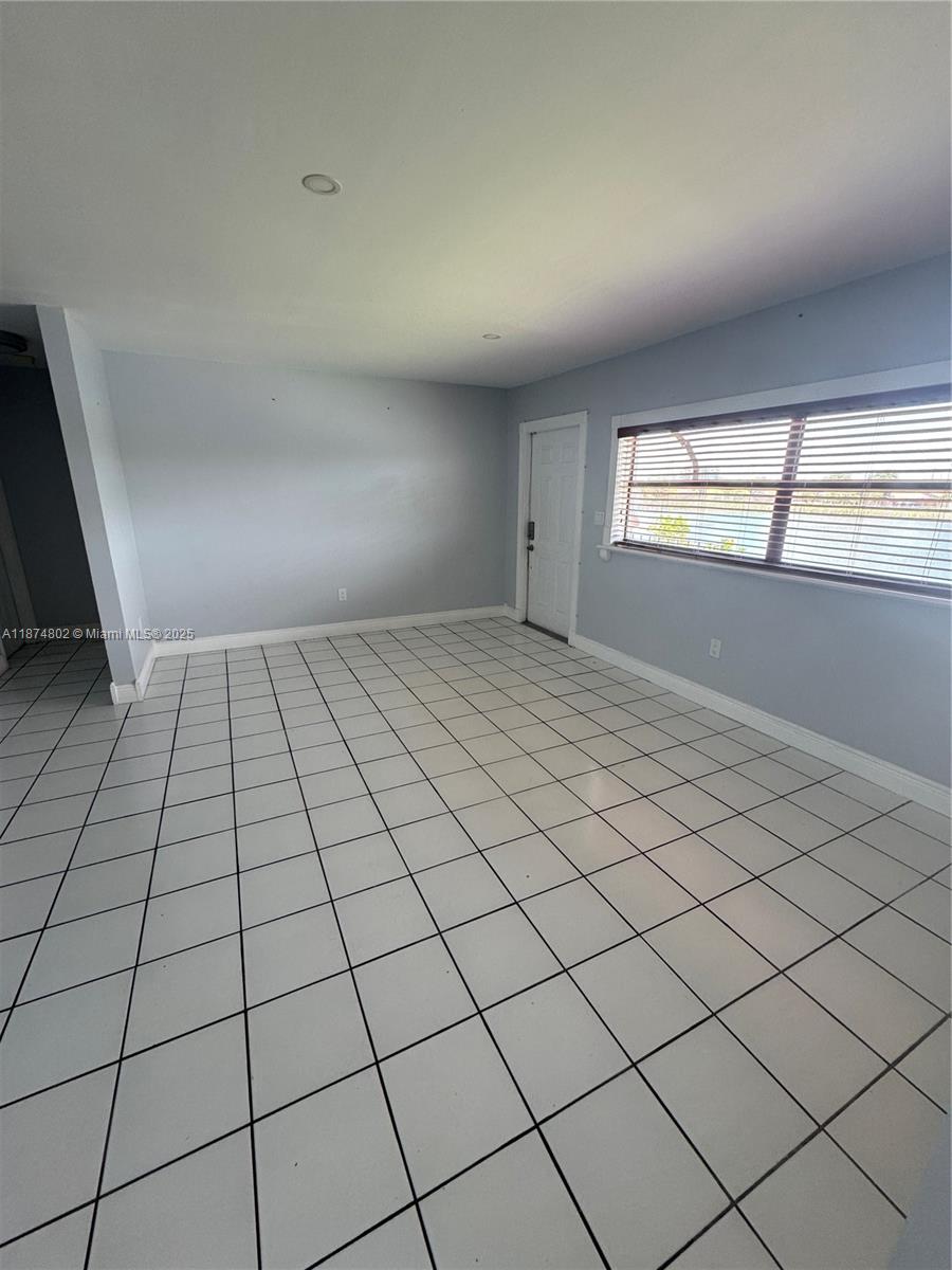 An empty room features light gray walls, white tile flooring, and a window with blinds — 13261 SW 17th Ln # 5, Miami FL 33175, MIAMI, FL