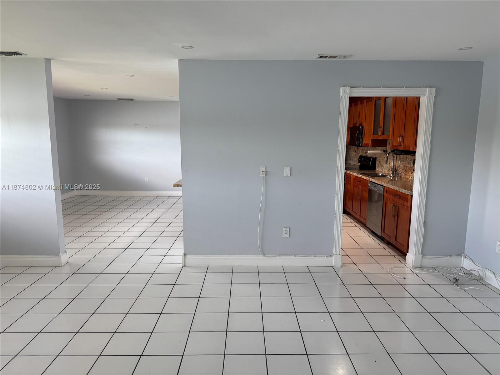 An interior view shows a tiled living area with a doorway leading to a kitchen — 13261 SW 17th Ln # 5, Miami FL 33175, MIAMI, FL
