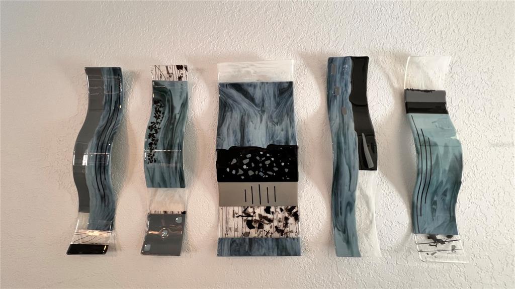 Five decorative, wavy glass wall art panels in shades of blue and black are displayed — 5556 LEGEND HILLS LANE, SPRING HILL, FL