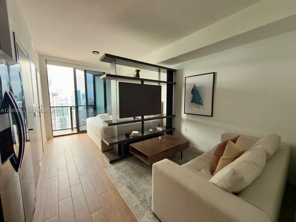 A studio apartment features a room divider with a television, a sofa, and a bed — 398 NE 5th St # 4313, Miami FL 33132, MIAMI, FL