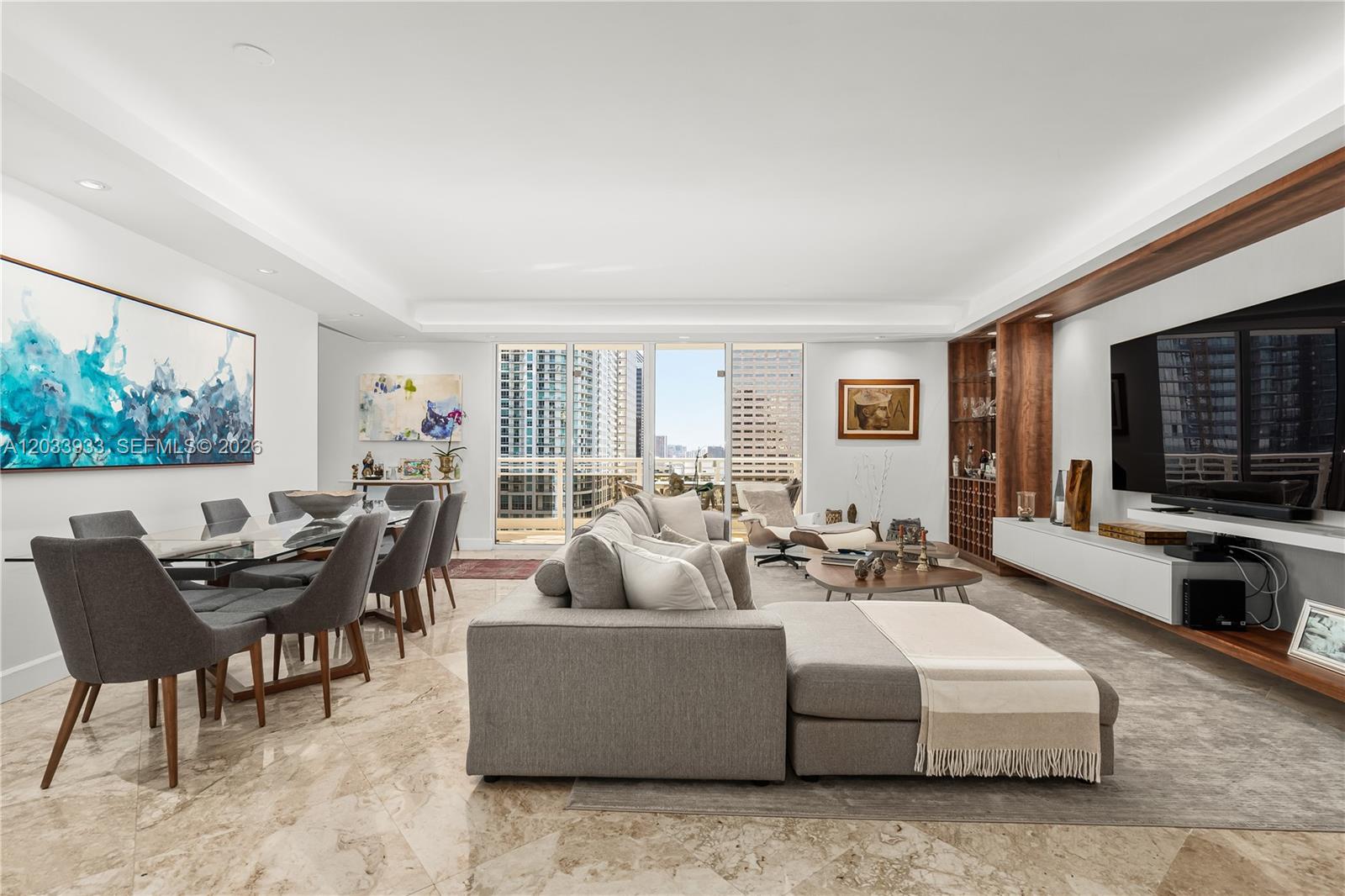 A modern living and dining area features marble floors, a large sectional, and city views — 901 BRICKELL KEY BL # 2206, Miami FL 33131, MIAMI, FL