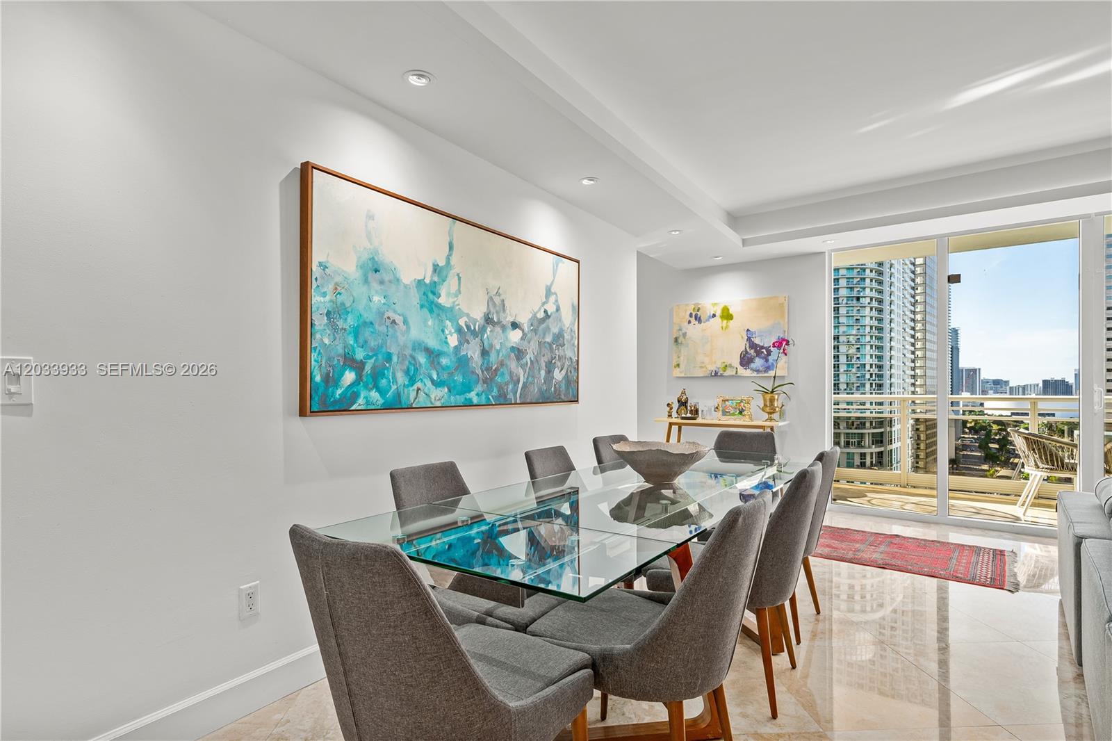 A dining room features a glass table, gray chairs, and large abstract wall art — 901 BRICKELL KEY BL # 2206, Miami FL 33131, MIAMI, FL