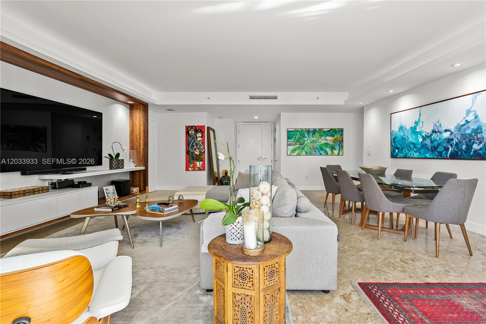 A modern living and dining area features a large television, gray sofa, and glass table — 901 BRICKELL KEY BL # 2206, Miami FL 33131, MIAMI, FL