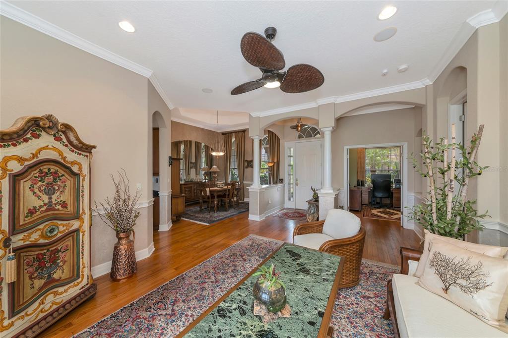 A living room features hardwood floors, a green marble coffee table, and a decorative armoire — 10412 WINDING STREAM WAY, BRADENTON, FL