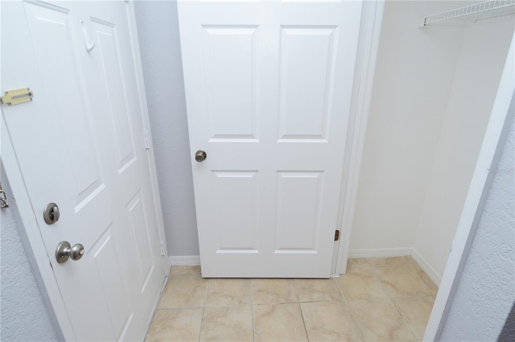 A tiled entryway features a white door with a deadbolt and a closed interior door — 10263 GANDY BOULEVARD N UNIT 2116, ST PETERSBURG, FL