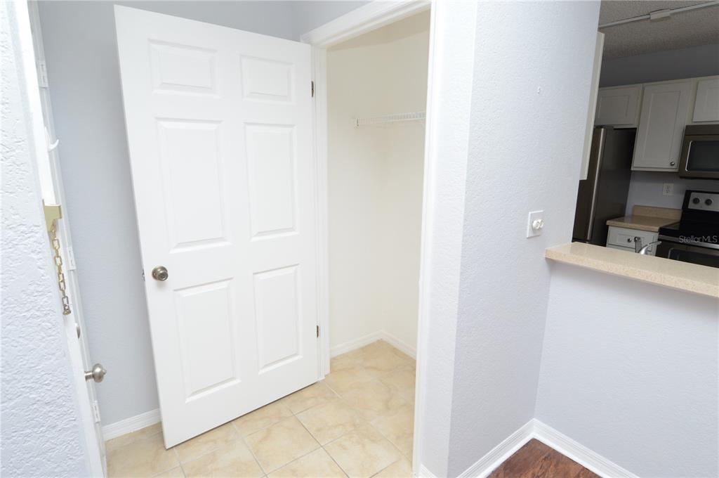 A white door opens to a small closet with tile flooring next to a kitchen — 10263 GANDY BOULEVARD N UNIT 2116, ST PETERSBURG, FL