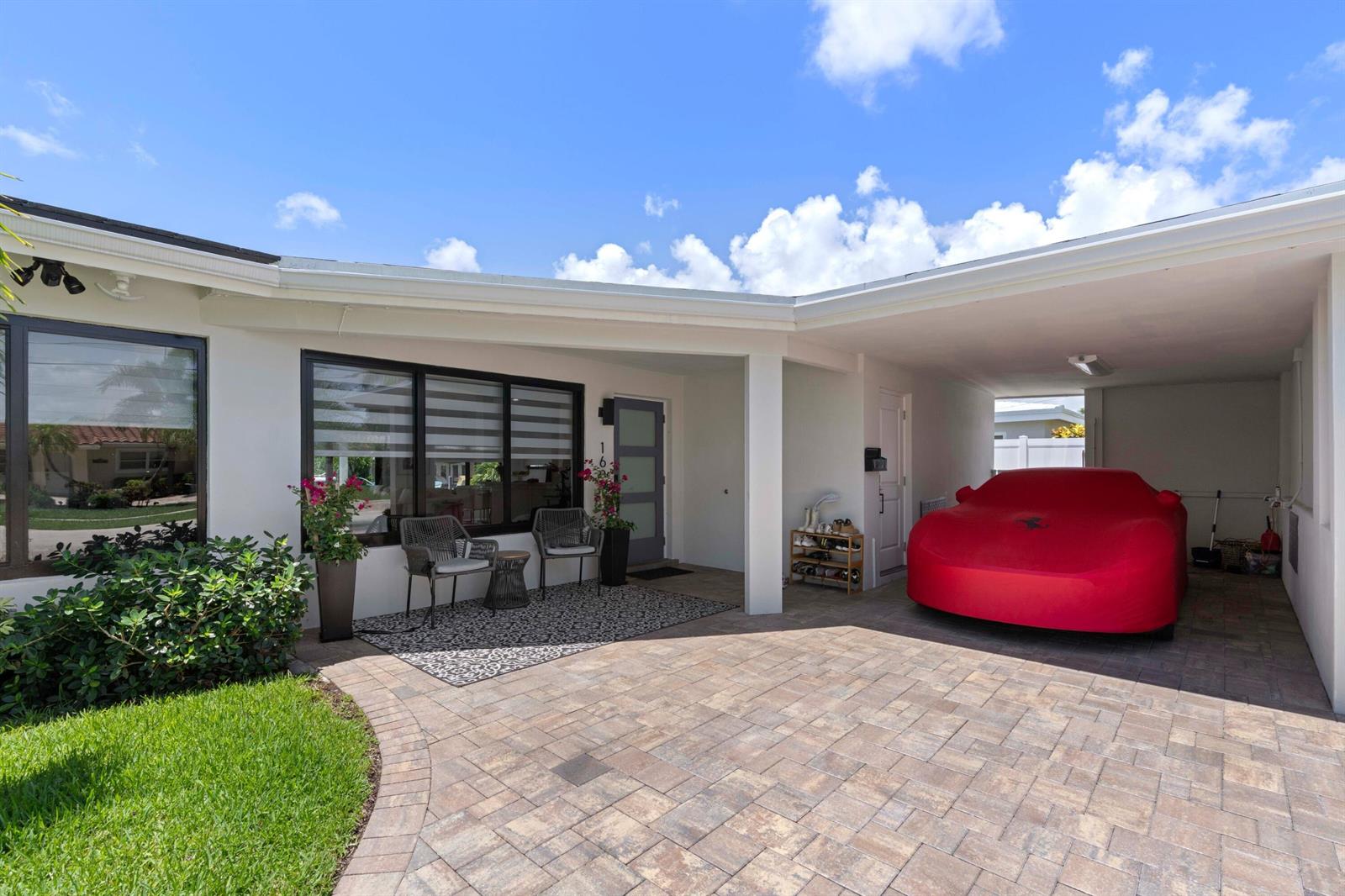 A paved driveway leads to a house entrance with a covered carport and a red car — 160 SE 12th Court, Pompano Beach FL 33060, POMPANO BEACH, FL