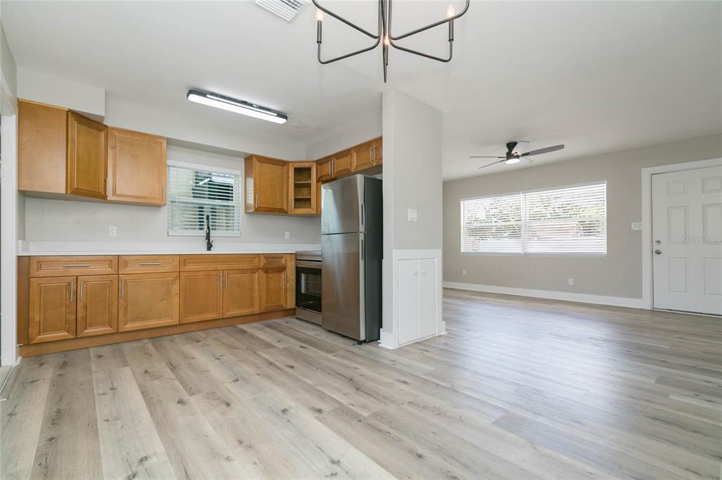 A kitchen with wood cabinets and stainless steel appliances opens to a living area — 2600 52ND AVENUE N UNIT B, ST PETERSBURG, FL