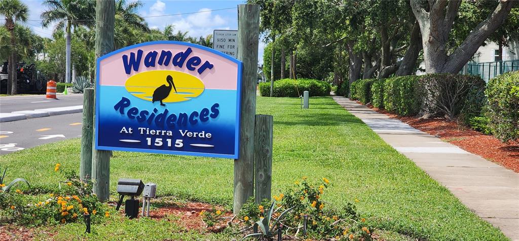 A sign for Wander Residences at Tierra Verde stands in a grassy area near a sidewalk — 1515 PINELLAS BAYWAY S UNIT 62, TIERRA VERDE, FL