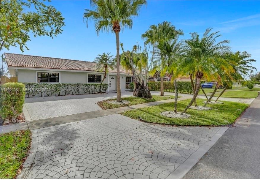 A single-story house with a paved driveway and several palm trees in the front yard — 5500 Buchanan St, Hollywood FL 33021, HOLLYWOOD, FL