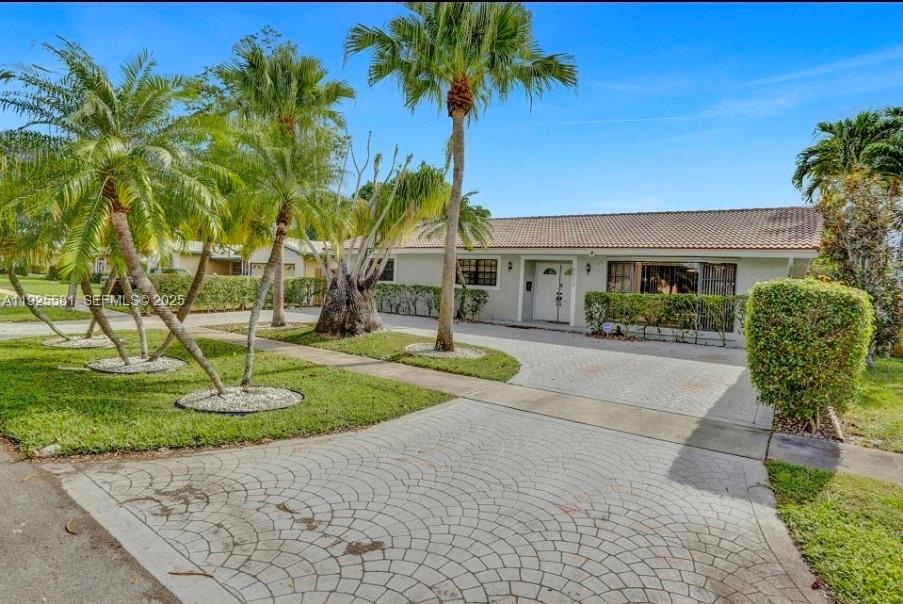 A single-story house with a paved driveway, palm trees, and a tiled roof — 5500 Buchanan St, Hollywood FL 33021, HOLLYWOOD, FL