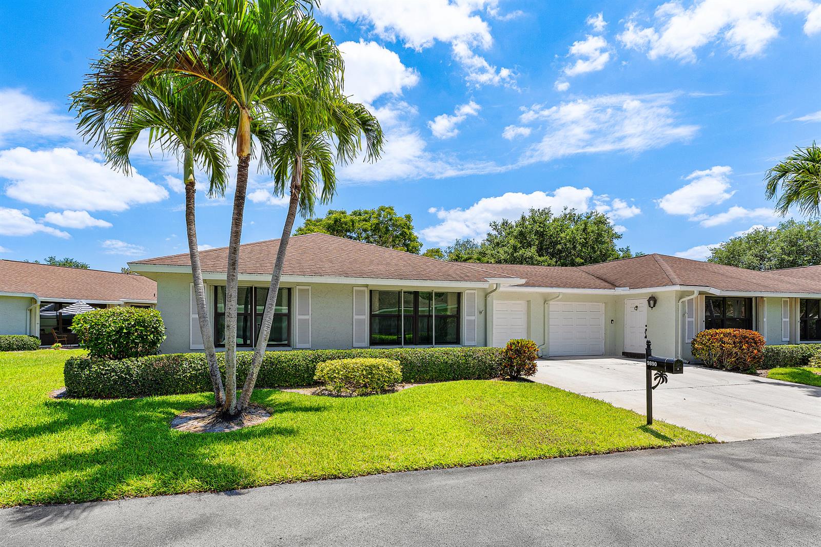 A single-story house with a brown roof, white garage doors, and a palm tree — 9890 Papaya Tree Trail # A, Boynton Beach FL 33436, BOYNTON BEACH, FL