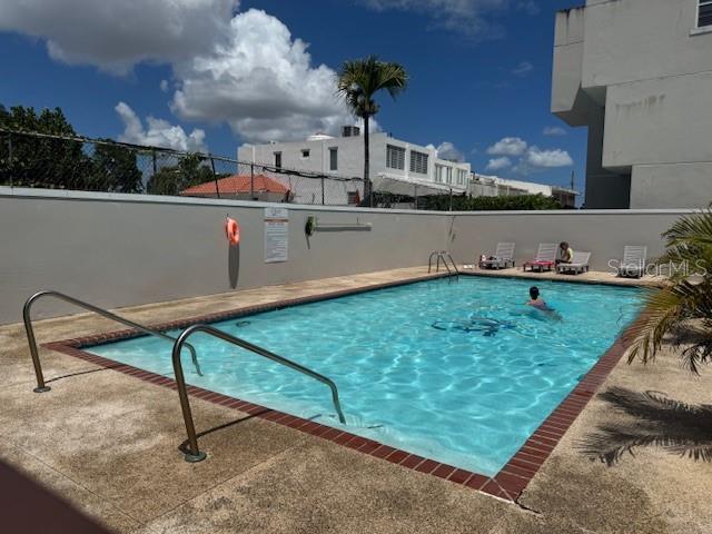 An outdoor swimming pool with a metal handrail is surrounded by a concrete deck — Ave. 50 A COND. QUINTA BALDWIN UNIT 1108, BAYAMON, PR