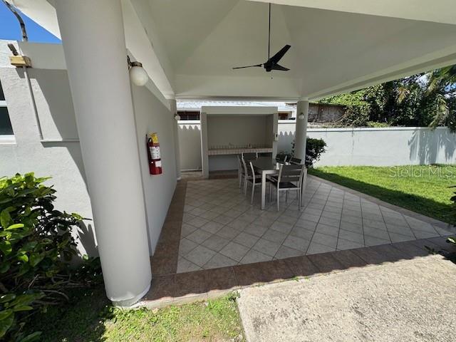 A covered outdoor patio features a dining set, a built-in counter, and a ceiling fan — Ave. 50 A COND. QUINTA BALDWIN UNIT 1108, BAYAMON, PR