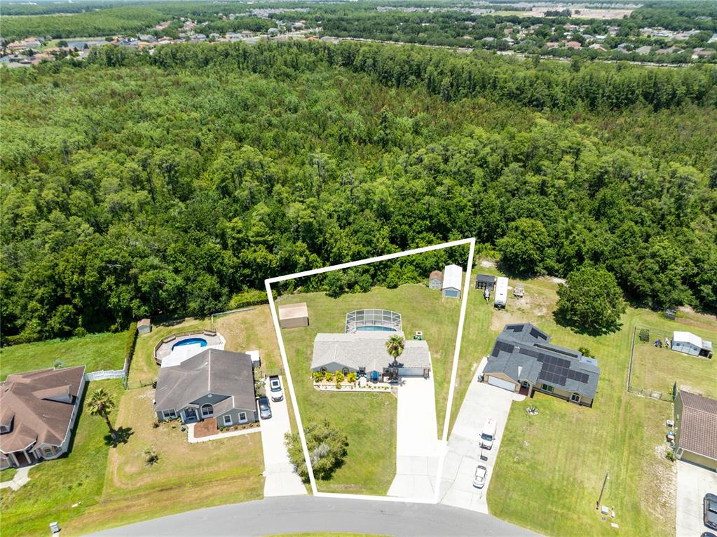 An aerial view shows a single-story house with a pool and large backyard — 3951 SANTA BARBARA ROAD, KISSIMMEE, FL