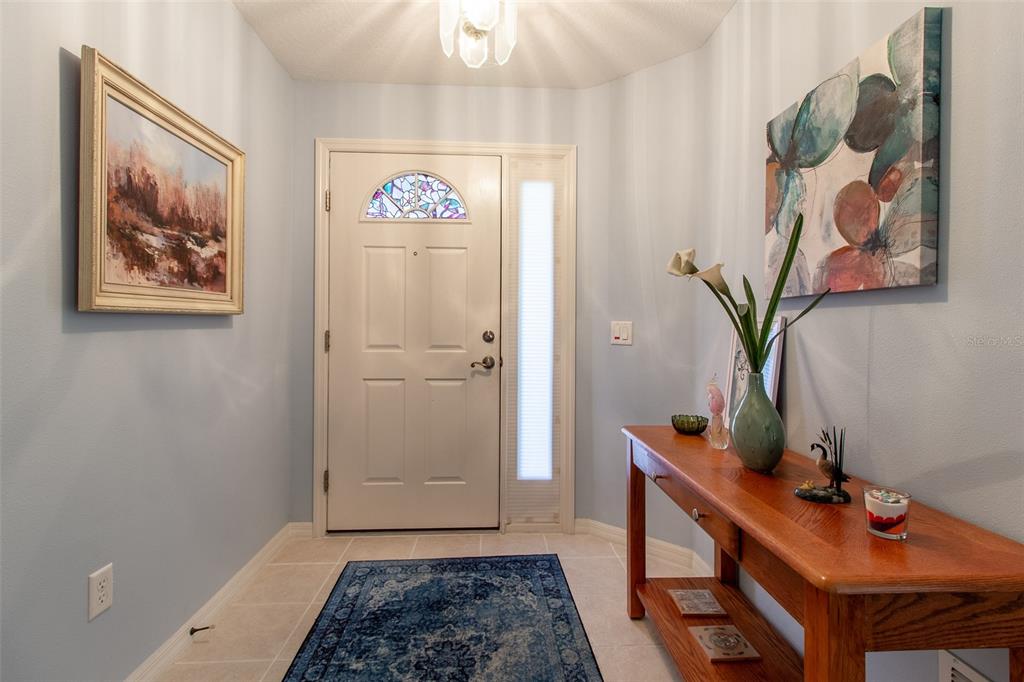 An entryway features a white front door with a stained-glass window, tile flooring, and console — 1768 SW 156TH LANE, OCALA, FL