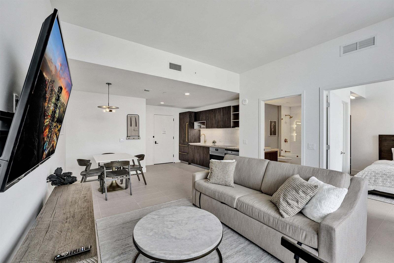 A modern living room features a sofa, coffee table, dining area, and an open kitchen — 159 NE 6th Street # 4813, Miami FL 33132, MIAMI, FL