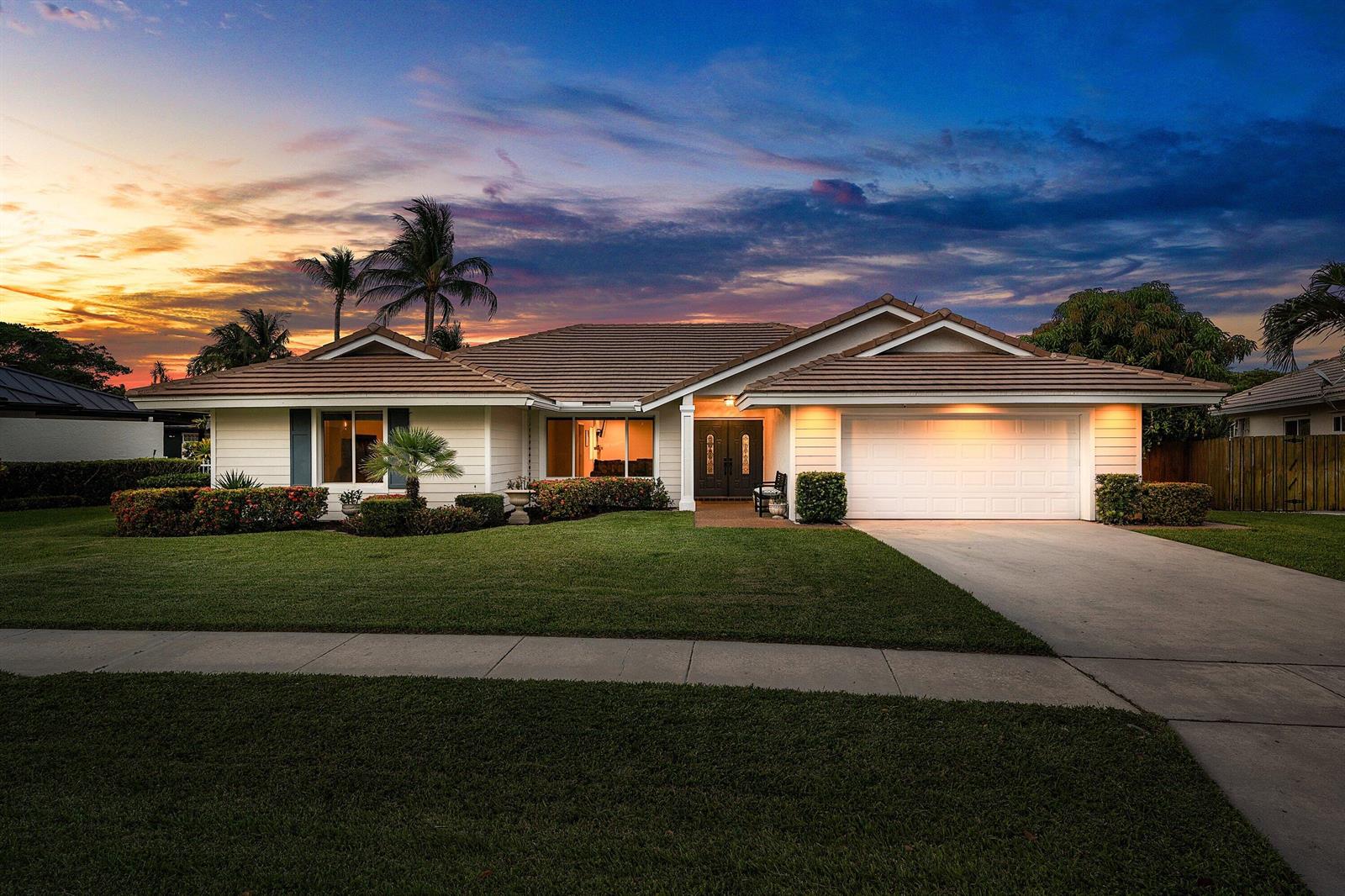 A single-story house with a white exterior, tiled roof, and a two-car garage at sunset — 763 Camino Lakes Circle, Boca Raton FL 33486, BOCA RATON, FL
