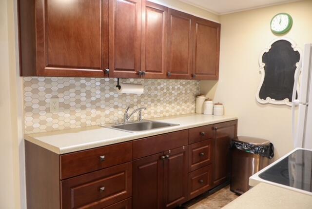 A kitchen features dark wood cabinets, a light countertop, and a hexagonal tile backsplash — 1011 Cornwall A # 1011, Boca Raton FL 33434, BOCA RATON, FL