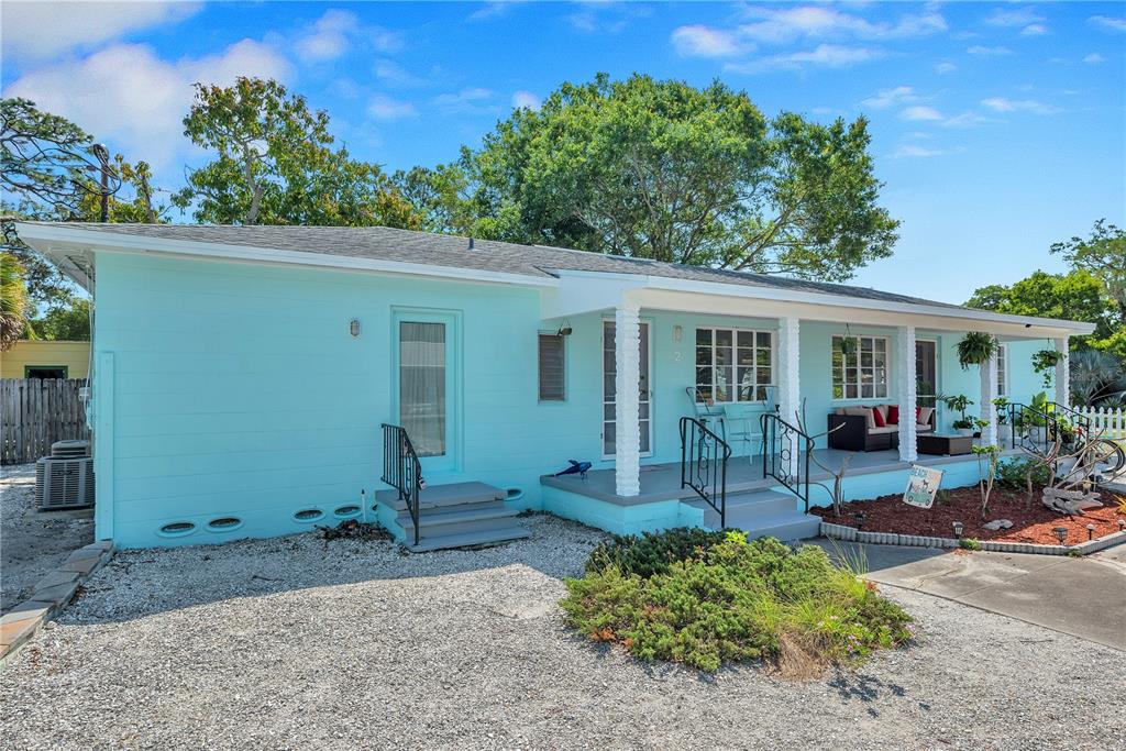 A light blue single-story house with a covered front porch and a gravel driveway — 5025 28TH AVENUE S, GULFPORT, FL