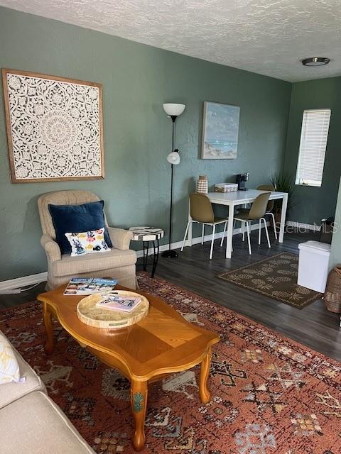 A living room features sage green walls, a patterned rug, and a wooden coffee table — 5025 28TH AVENUE S, GULFPORT, FL