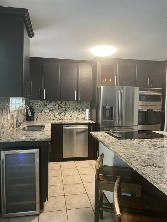 A kitchen features dark cabinets, granite countertops, stainless steel appliances, and a wine cooler — 00 ALBACORA, VEGA ALTA, PR
