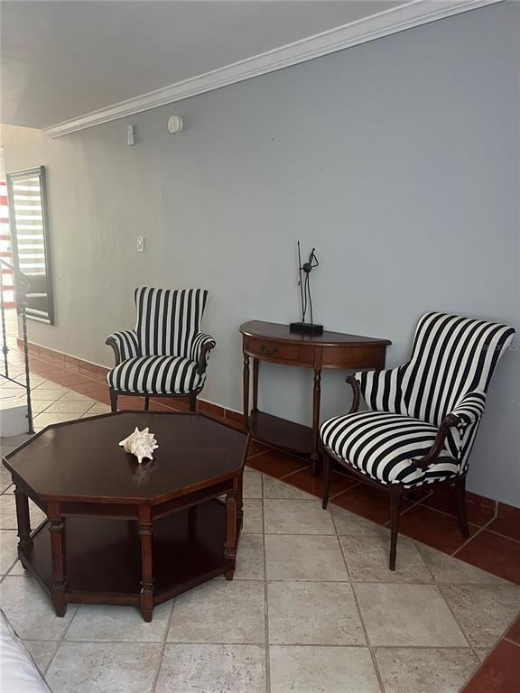 A room with tile floors features two striped armchairs, a wooden console table, and an octagonal table — 00 ALBACORA, VEGA ALTA, PR