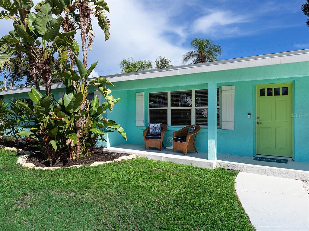 A turquoise house exterior features a lime green front door and a small covered porch — 3049 WOOD STREET, SARASOTA, FL