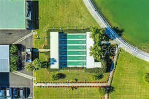 An aerial view shows a shuffleboard court facility next to a parking lot and lake — 4780 COVE CIRCLE UNIT 101, ST PETERSBURG, FL