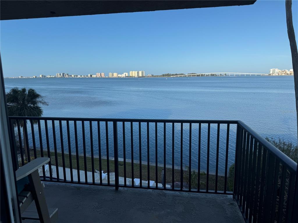 A balcony with a black metal railing overlooks a wide bay and a distant bridge — 9 TURNER STREET UNIT 11, CLEARWATER, FL