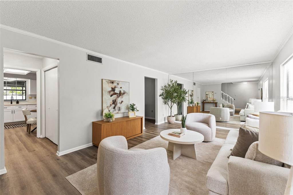 A living room features light wood flooring, a mirrored wall, and neutral-toned furniture — 14809 WINDING CREEK COURT, TAMPA, FL