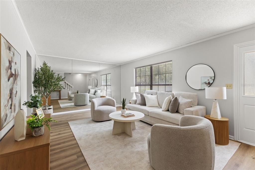 A living room features light-colored furniture, a large wall mirror, and wood-look flooring — 14809 WINDING CREEK COURT, TAMPA, FL