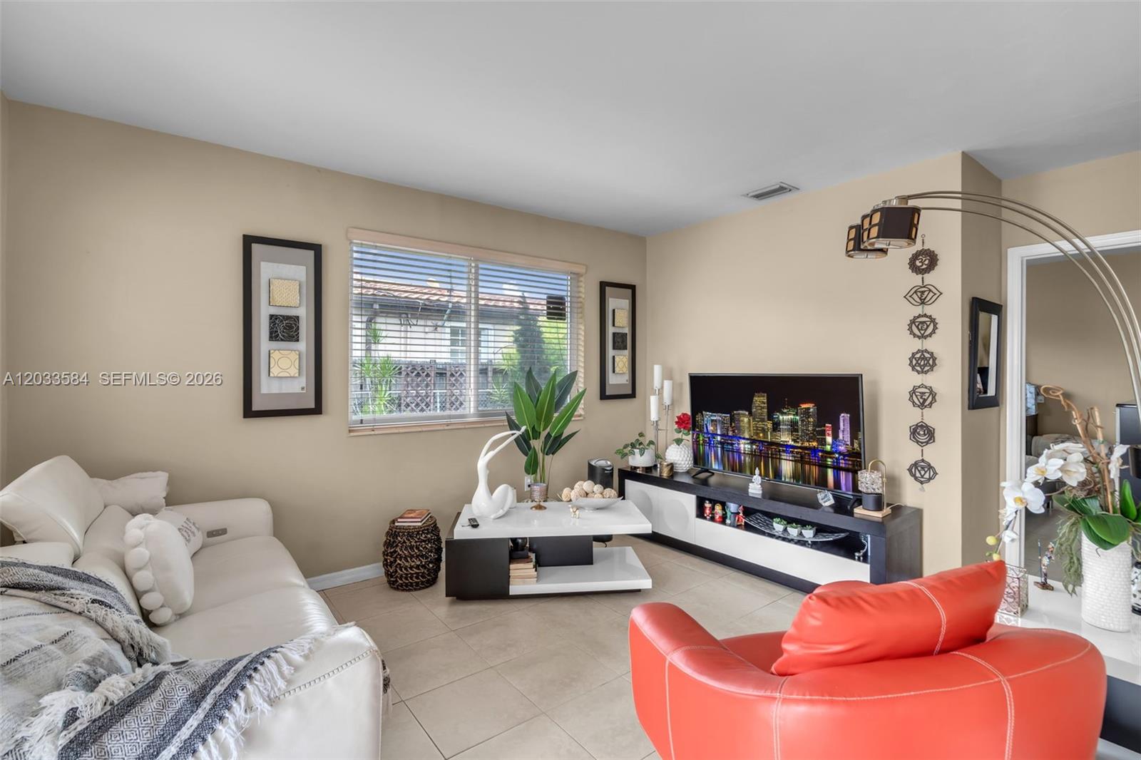 A living room features a white sofa, a red armchair, and a television on a console — 247 NW 51st Ave, Miami FL 33126, MIAMI, FL