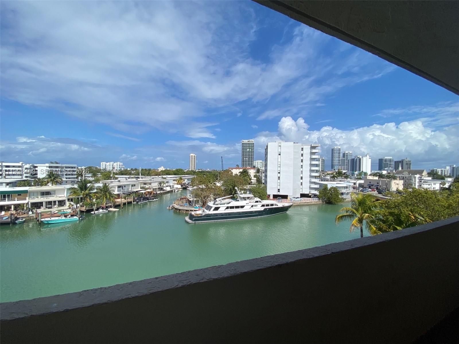 A high-angle view shows a canal with boats and yachts surrounded by residential buildings — 7125 Bay Dr # 506, Miami Beach FL 33141, MIAMI BEACH, FL