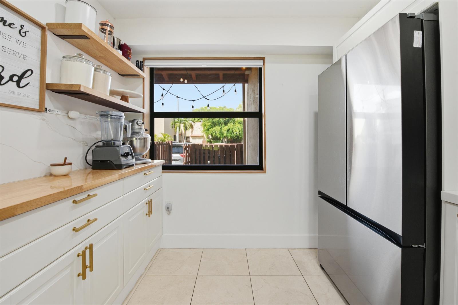 A kitchen features white cabinets, wood countertops, open shelving, and a stainless steel refrigerator — 371 W Park Drive # 17, Miami FL 33172, MIAMI, FL