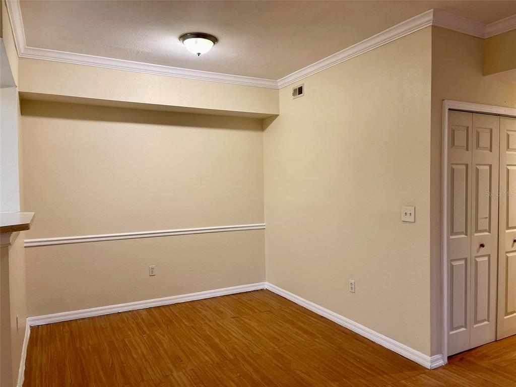 An empty room with light-colored walls, chair rail molding, and wood-look flooring — 5550 P G A BOULEVARD UNIT 5126, ORLANDO, FL