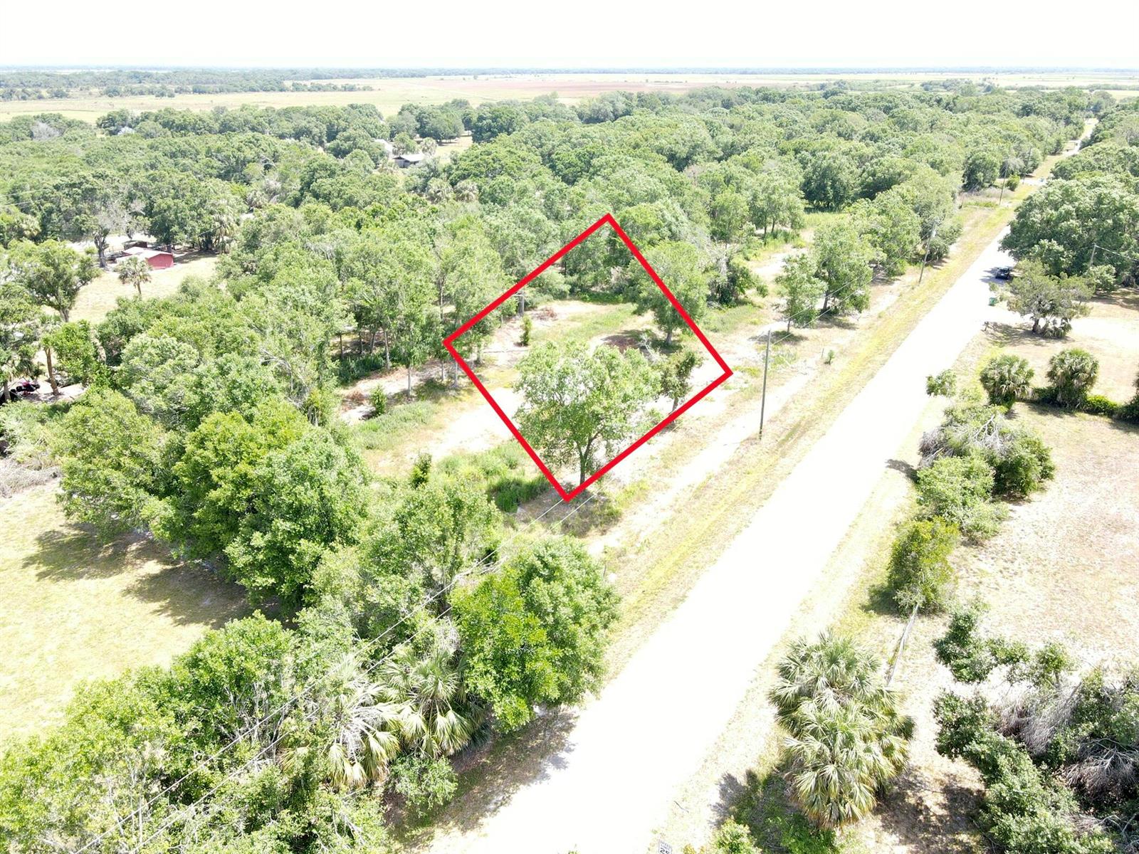 An aerial view shows a rectangular plot of land outlined in red beside a road — 7813 NW 93rd Court, Okeechobee FL 34972, OKEECHOBEE, FL