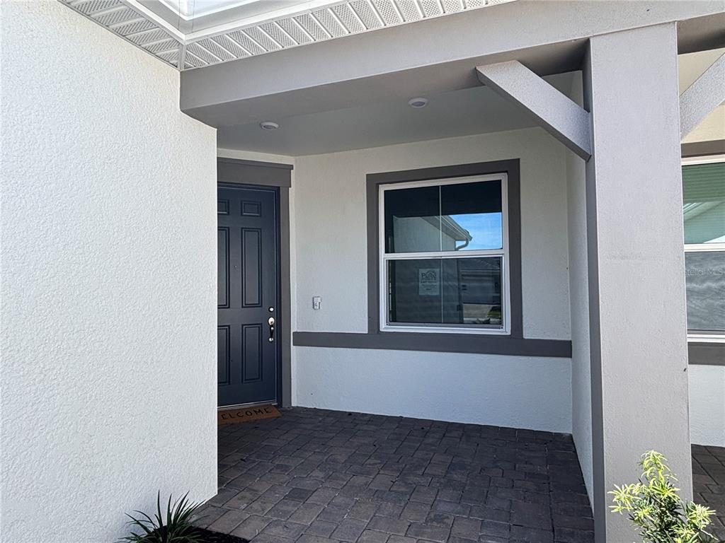 A single-story house with two garage doors and a paved driveway under a blue sky — 1596 TAVIRA PLACE, ENGLEWOOD, FL