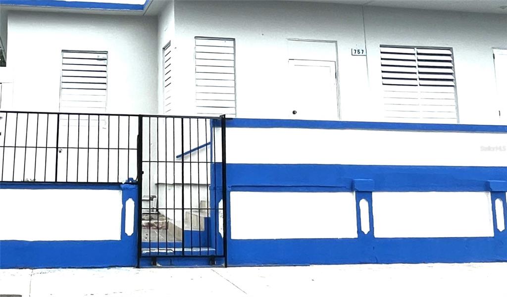 A white building with blue trim features a black metal gate and louvered windows — 757 HIPODROMO, SAN JUAN, PR
