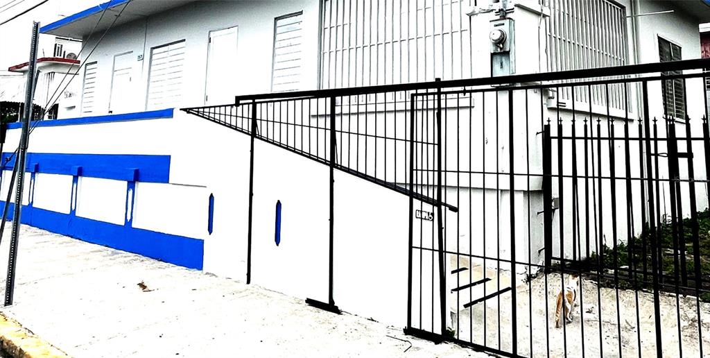 A white building with blue trim features a black metal fence and a small cat — 757 HIPODROMO, SAN JUAN, PR