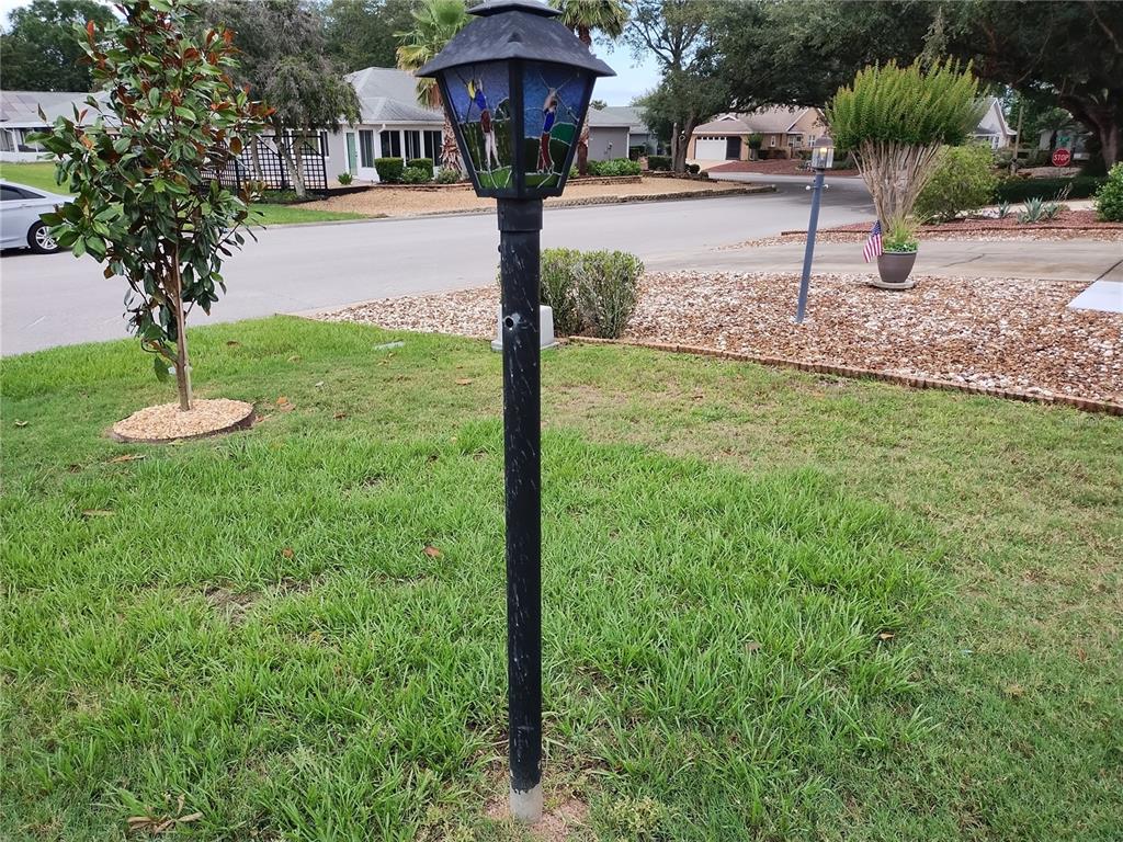 A decorative golf-themed lamp post stands in a residential front yard with a paved street — 9013 SW 91ST CIRCLE, OCALA, FL