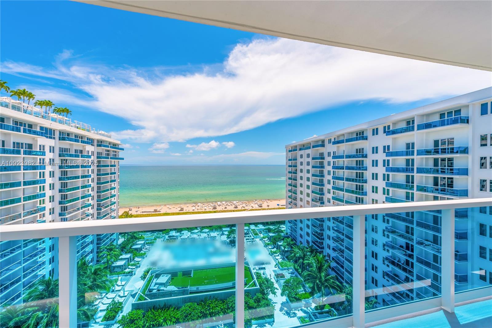 A balcony view overlooks a swimming pool area, a sandy beach, and the ocean — 102 24th St # 1544, Miami Beach FL 33139, MIAMI BEACH, FL