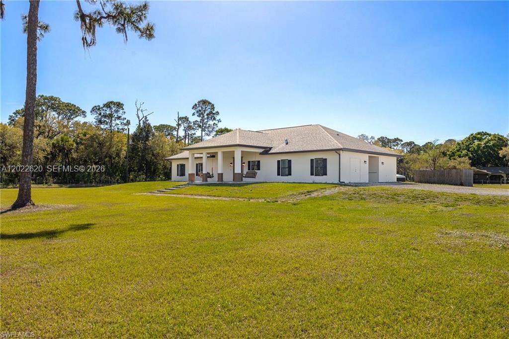 A single-story house with a covered porch sits on a large, grassy lot — 5535 COUNTY ROAD 78, La Belle FL 33935, LA BELLE, FL