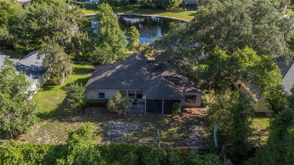 An aerial view shows a house with a screened-in patio and a backyard near a pond — 177 OVEROAKS PLACE, SANFORD, FL