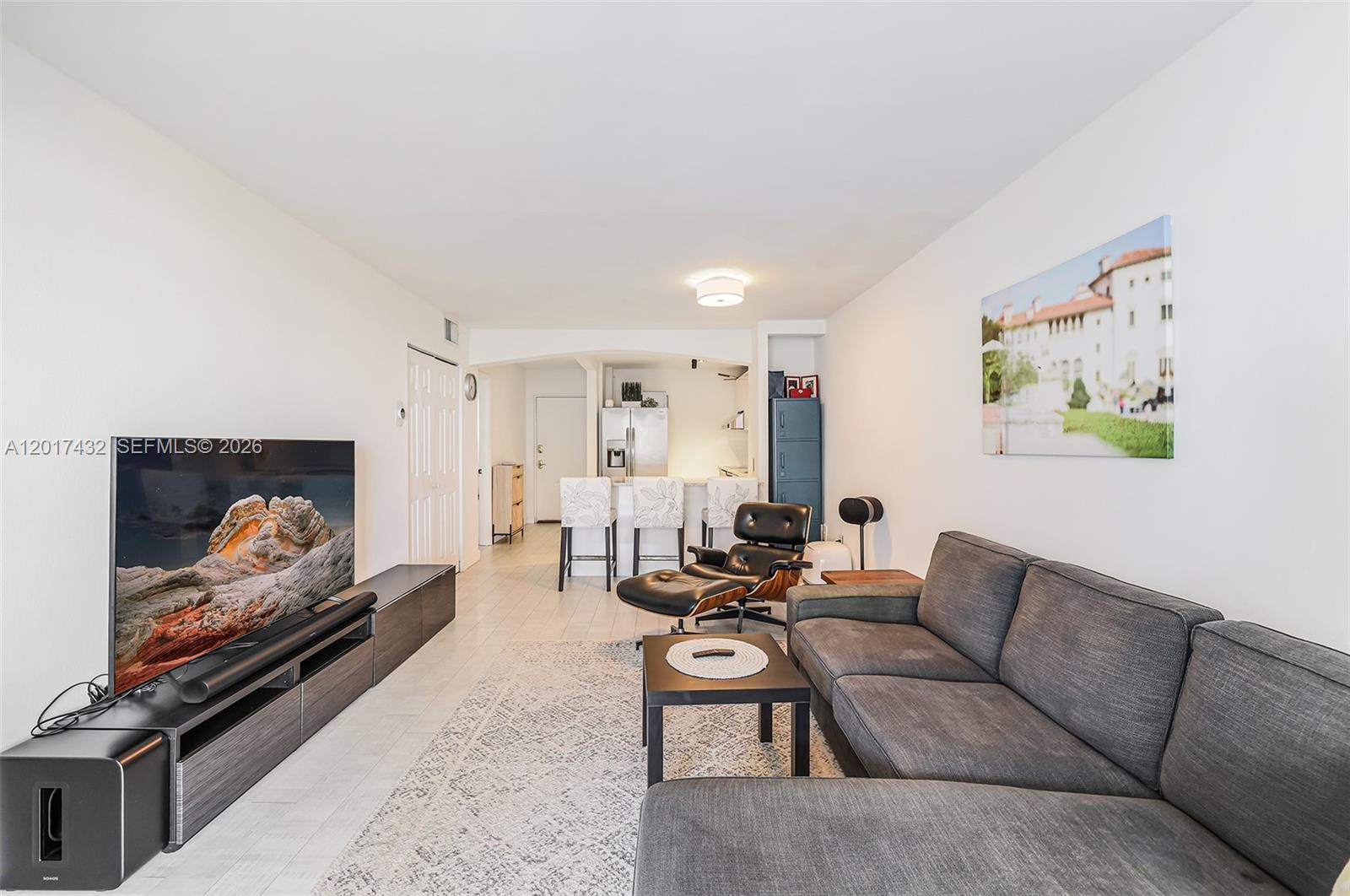 A living room features a gray sectional sofa, a television console, and an open kitchen — 1331 Lincoln Rd # 704, Miami Beach FL 33139, MIAMI BEACH, FL